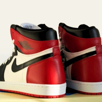 High heel view of Jordan 1 Black sneakers with red and black accent